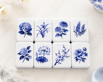 May include: Eight rectangular white tiles arranged in two rows, each featuring a distinct blue floral illustration. The designs include various blossoms such as hydrangeas, lotuses, and chrysanthemums, rendered in a classic blue and white style.