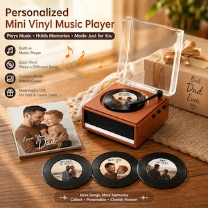 Peut inclure: Un lecteur de musique carré marron avec un couvercle transparent à charnière et un disque vinyle noir sur le dessus. L'ensemble comprend trois disques vinyles noirs supplémentaires avec des étiquettes photo personnalisées et une photo carrée.