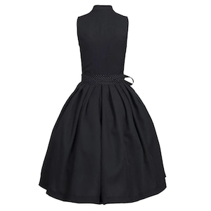 May include: A black sleeveless dress with a white polka dot trim around the waist. The dress has a full skirt and a fitted bodice.
