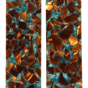 May include: Two rectangular resin pieces with a turquoise base, embedded with copper-colored fragments. The fragments vary in size and shape, creating a mosaic-like appearance. The copper pieces have a metallic sheen.