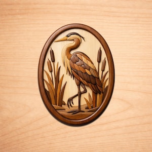 Puede incluir: Arte mural ovalado de madera que representa una garza en un entorno de marisma. La garza está representada en tonos marrones y beige, con cabeza negra y pico amarillo. Juncos y espigas rodean al ave, todo dentro de un marco de madera marrón oscuro.