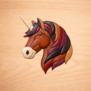 May include: Wooden unicorn head sculpture with a cream-colored horn, brown body, and a mane of red, black, and purple wood pieces. The unicorn is set against a light wood grain background.