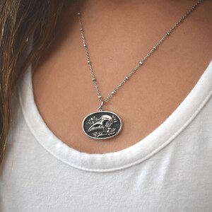 May include: A silver chain necklace with a pendant featuring a detailed skull with floral accents.