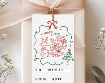 May include: A gift tag with a red and green illustration of Santa Claus in a sleigh pulled by a reindeer, with the words "Holiday Express." The tag is attached to a wrapped gift with a beige ribbon and bow. The tag reads "To: Charlie" and "From: Santa."