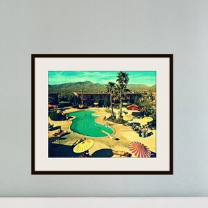 Pode incluir: Uma fotografia vintage de uma piscina em um resort. A piscina &eacute; cercada por palmeiras e guarda-s&oacute;is coloridos. A foto tem um visual desbotado e retr&ocirc;.