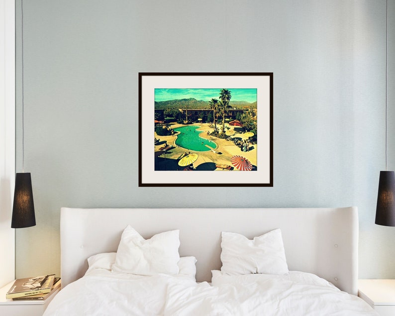 Pode incluir: Uma fotografia vintage de uma piscina em um resort. A piscina &eacute; cercada por palmeiras e guarda-s&oacute;is coloridos. A foto tem um visual desbotado e retr&ocirc;.