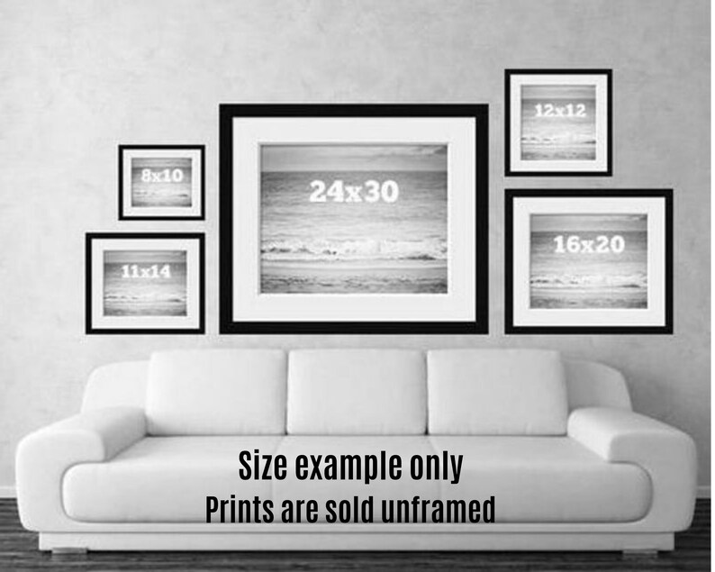 May include: A collection of framed prints in various sizes, including 8x10, 11x14, 12x12, 16x20, and 24x30 inches, displayed on a wall. The prints feature a black and white seascape. The text "Size example only Prints are sold unframed" is visible.
