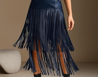 May include: Navy blue faux leather skirt with long fringe detailing. The skirt has a high waist and a decorative metal accent. The word "SNAZZY" is printed in white at the top left corner of the image.