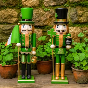 May include: Two decorative wooden nutcrackers in green and gold attire, celebrating St. Patrick's Day. One holds an Irish flag, the other a pot of gold with "GOOD LUCK" on it. Both wear hats and have mustaches.