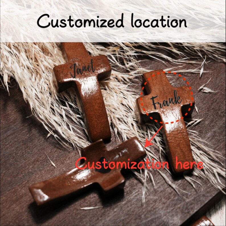 May include: Three brown wooden crosses with personalized names, "Janet" and "Frank", engraved on them. The crosses are displayed on a dark wooden surface with dried plants in the background. Text reads "Customized location" and "Customization here".