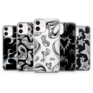 May include: A collection of five phone cases with various designs. The cases feature a mix of black and white backgrounds with metallic silver abstract shapes, hearts, and stars. The cases are designed to fit a smartphone.