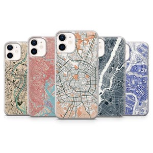 May include: A collection of five phone cases, each featuring a unique city map design. The cases showcase a variety of color palettes, including beige, red, gray, and blue, with intricate street and landmark details. The cases are designed to fit a smartphone.