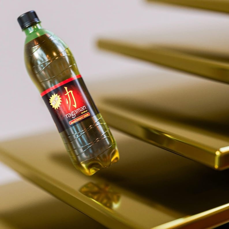 May include: A clear plastic bottle with a black cap and green neck, filled with a yellow liquid. The label reads "ragaman" with Japanese characters and "Original Energy Drink". The bottle is positioned on a gold-colored surface.
