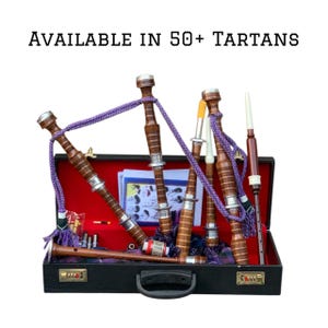 May include: A set of bagpipes in a black case with a red interior. The bagpipes are brown with silver accents and purple cords. The case has the text "AVAILABLE IN 50+ TARTANS".