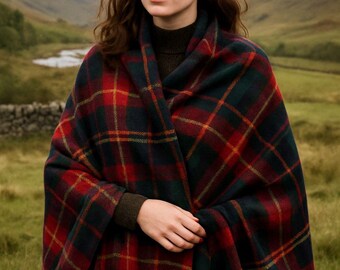 May include: A woman wearing a red, green, and yellow plaid shawl with fringe. The shawl is draped over a dark green turtleneck sweater. The background features a landscape with mountains and a body of water.
