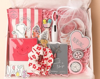 Puede incluir: Una caja de regalo llena de artículos con temática de enfermería. Incluye una bolsa a rayas rosas y blancas, pegatinas, un cuaderno rojo, una goma para el pelo con flores rojas, un collar, un reloj rosa y un letrero en forma de corazón que dice "NURSING".