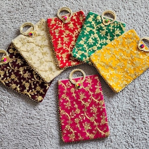 May include: A collection of six embroidered clutch bags in various colors: burgundy, cream, red, green, yellow, and fuchsia. Each bag features a gold floral design and a circular gold handle with a decorative accent.