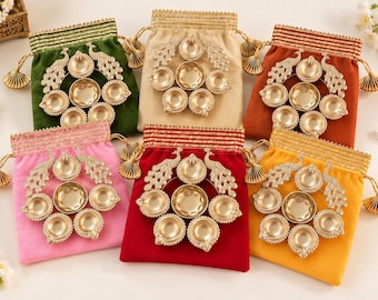 Può includere: Sei sacchetti in velluto con coulisse nei colori verde, beige, arancione, rosa, rosso e giallo, ciascuno con un portacandela diya dorato a forma di pavone con sette coppette circolari disposte a cerchio e nappe decorative.