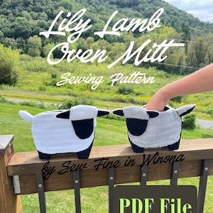 May include: Two oven mitts shaped like lambs, one white and one gray, featuring black faces and feet. The text Lily Lamb Oven Mitt Sewing Pattern by Sew Fine in Winona and PDF File is overlaid on the image of the two fabric lamb oven mitts.