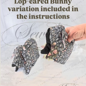 Peut inclure: Deux oreilles de lapin en tissu, dont une tenue par une main, avec un motif floral sur fond sombre. Le texte indique "Variation de lapin &agrave; oreilles tombantes incluse dans les instructions". L'int&eacute;rieur des oreilles est &agrave; pois noirs et blancs.
