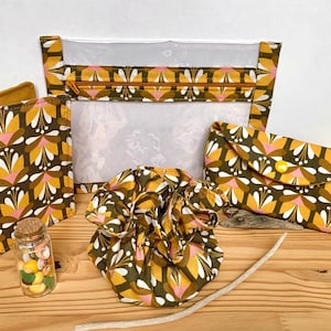 Kit de voyage comprenant un étui à lunettes, une bijoulette, un étui à passeport, une pochette transparente + 1 surprise