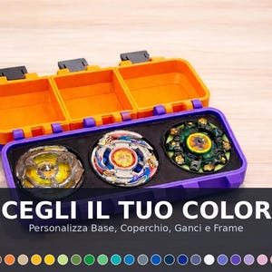 Può includere: Una custodia rettangolare con coperchio arancione e base viola contenente tre trottole circolari. La custodia presenta chiusure nere e inserti in gommapiuma nera. Il testo sull'immagine recita: SCEGLI IL TUO COLORE, Personalizza Base, Coperchio, Ganci e Frame.