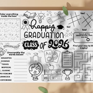 May include: Black and white graduation activity sheet with the text "Happy Graduation Class of 2026". Includes a maze, tic-tac-toe, unscramble words, and a coloring section. Features graduation caps, books, and a trophy.