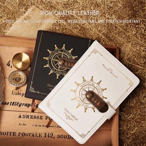 May include: Two leather-bound notebooks, one black and one white, with gold nautical-themed designs and combination locks. The text "HIGH QUALITY LEATHER" is visible. The notebooks are labeled "NAUTICAL CLASSICAL" and "Retro Codebook".