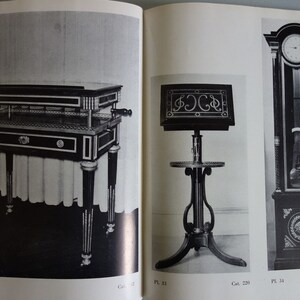 Puede incluir: Imagen en blanco y negro de muebles antiguos. Incluye una mesa con cajones, un atril y un reloj de pie. La mesa tiene patas decorativas y un tirador. El reloj tiene un p&eacute;ndulo y una esfera redonda.