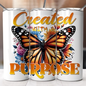 May include: White tumbler with a butterfly and floral design. The tumbler has the text "Created with a Purpose" in yellow letters.