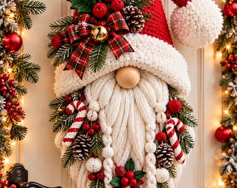 May include: A crochet Santa gnome wall hanging featuring a tall red hat with a white pom-pom, a thick white yarn beard with braided sections, a round wooden nose, and decorative accents including pine sprigs, red berries, and candy canes.