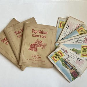 May include: A collection of vintage stamp books and saver books. The books are in various sizes and feature the text "Top Value Stamps" in red. The covers are tan with illustrations of an elephant and other graphics.