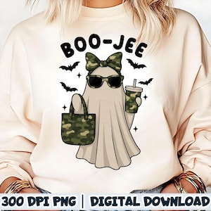 May include: A beige sweatshirt with a graphic of a ghost wearing sunglasses, a camouflage bow, and holding a camouflage tote bag and a drink. The text "BOO-JEE" is above the ghost, with bats and stars around it.