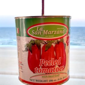 Könnte beinhalten: Eine Dose geschälter Tomaten von La San Marzano mit Basilikumblatt. Das Etikett ist grün und weiß und zeigt Abbildungen roter Tomaten. Nettogewicht: 3,01 kg.