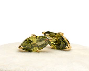 Puede incluir: Un par de pendientes de oro con piedras preciosas verdes en forma de marquesa.