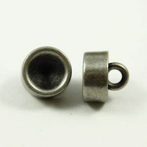 May include: Two silver-toned metal buttons with a loop on one button. The buttons are round and have a slightly raised edge.