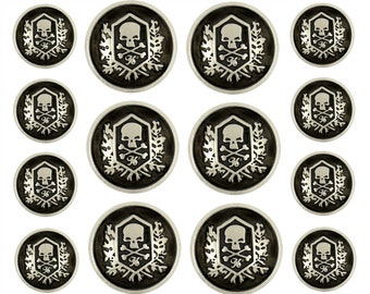 Könnte beinhalten: Set mit 12 silberfarbenen Knöpfen mit Totenkopf- und Knochen-Motiv. Die Knöpfe sind schwarz mit einem silbernen Totenkopf- und Knochen-Motiv. Die Knöpfe sind in verschiedenen Größen.