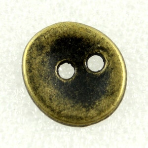 May include: A two-hole, round, antique gold-colored metal button.