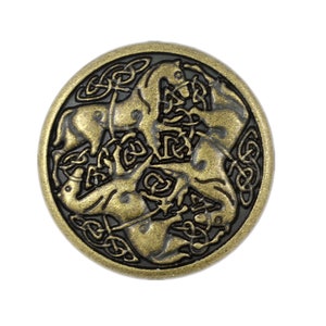 May include: A gold-toned metal button with a Celtic knot design featuring four horses intertwined. The button has a black background and a raised design.
