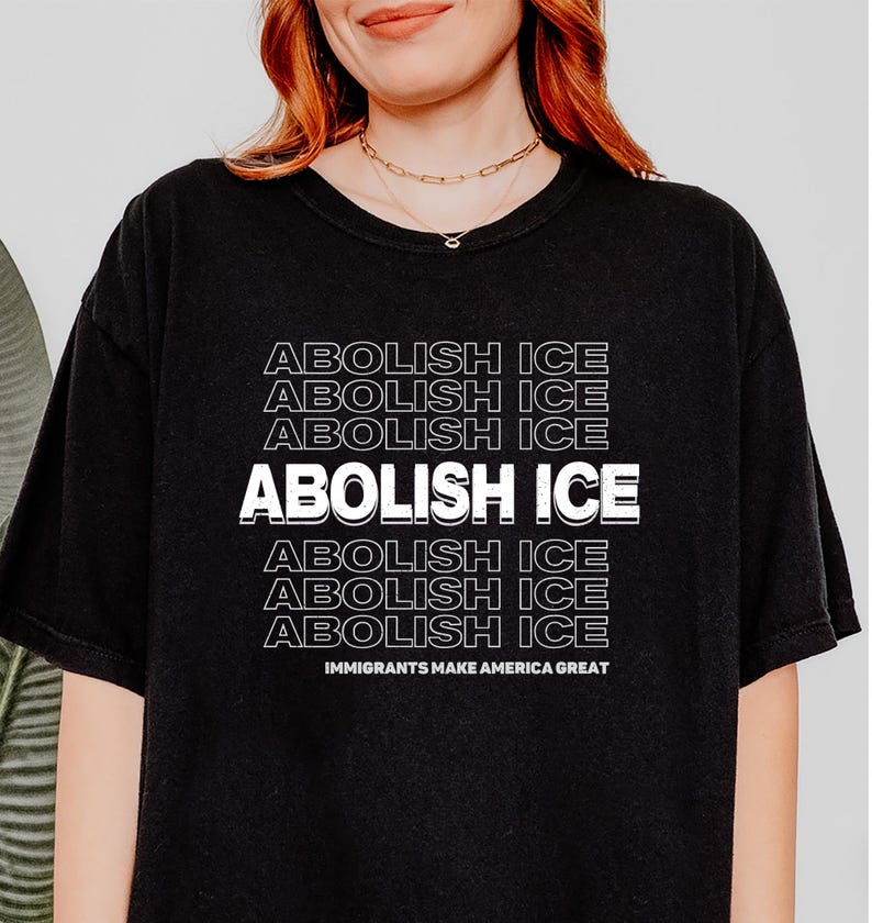 Puede incluir: Camiseta negra con la frase "ABOLISH ICE" en fuente blanca apilada. La frase "IMMIGRANTS MAKE AMERICA GREAT" est&aacute; impresa debajo. La camiseta es de estilo casual.
