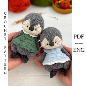 Puede incluir: Dos muñecos de pingüino hechos a mano con ganchillo. Uno lleva un vestido verde, el otro un vestido azul. Los pingüinos tienen cuerpos grises, caras color crema y ojos negros. La imagen también incluye el texto "CROCHET PATTERN" y "PDF -- ENG".