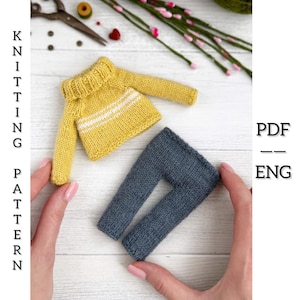 May include: A miniature knitted yellow sweater with white stripes and grey trousers. The text "KNITTING PATTERN" is printed vertically on the left side of the image. The text "PDF -- ENG" is printed vertically on the right side of the image.