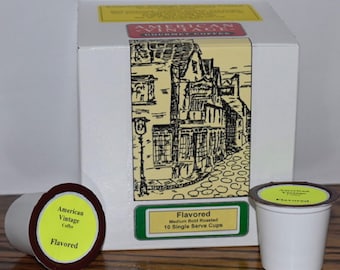 May include: A box of 10 single-serve flavored coffee cups. The box is white with a black and white illustration of a building and the text "American Vintage Gourmet Coffee". The coffee cups are white with a yellow label that says "American Vintage Coffee Flavored".