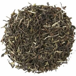 May include: Loose leaf black tea with a dark green color. The tea leaves are long and thin, with a few white pieces mixed in.