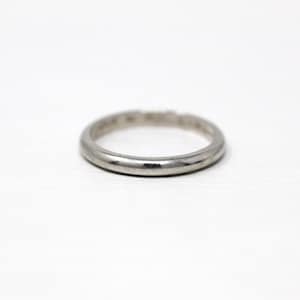 May include: A simple silver wedding band.