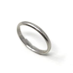 May include: A silver-colored ring with a smooth, rounded band. The ring is set against a white background, highlighting its simple, elegant design. This piece of jewelry is suitable for everyday wear.