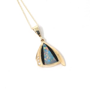 Op de afbeelding: Een gouden hangerketting met een driehoekige opaalsteen. De opaal heeft een blauwe en iriserende kleur. De hanger is omlijst door een gouden zetting met drie kleine diamanten aan één kant. De ketting is ook van goud.