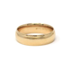 May include: A gold-colored ring with a rounded band. The ring has a smooth, polished surface and a classic design. The ring is likely made of gold and is suitable for everyday wear.