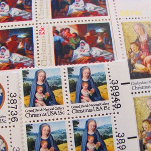 以下が含まれることがあります： 宗教的な芸術作品と「Christmas US postage」というテキストが書かれた、ヴィンテージのクリスマス切手のコレクションです。
