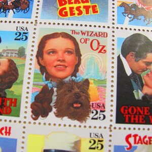 May include: A sheet of 10 US postage stamps featuring classic movie scenes. The stamps feature scenes from Gone With The Wind, The Wizard of Oz, and Stagecoach. Each stamp has a value of 25 cents.